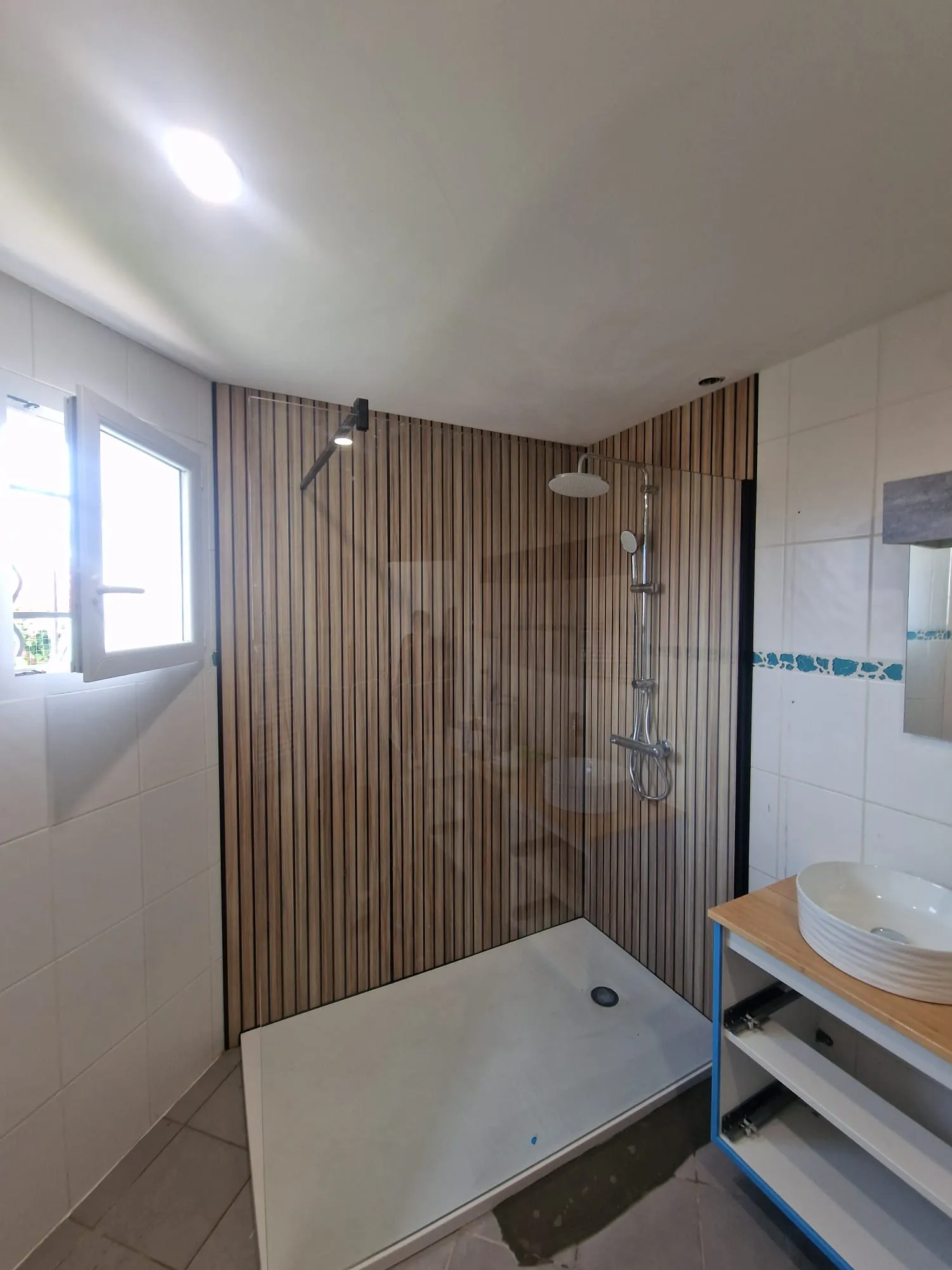 Douche à l’italienne avec panneau décoratif effet lambris bois et receveur extra-plat