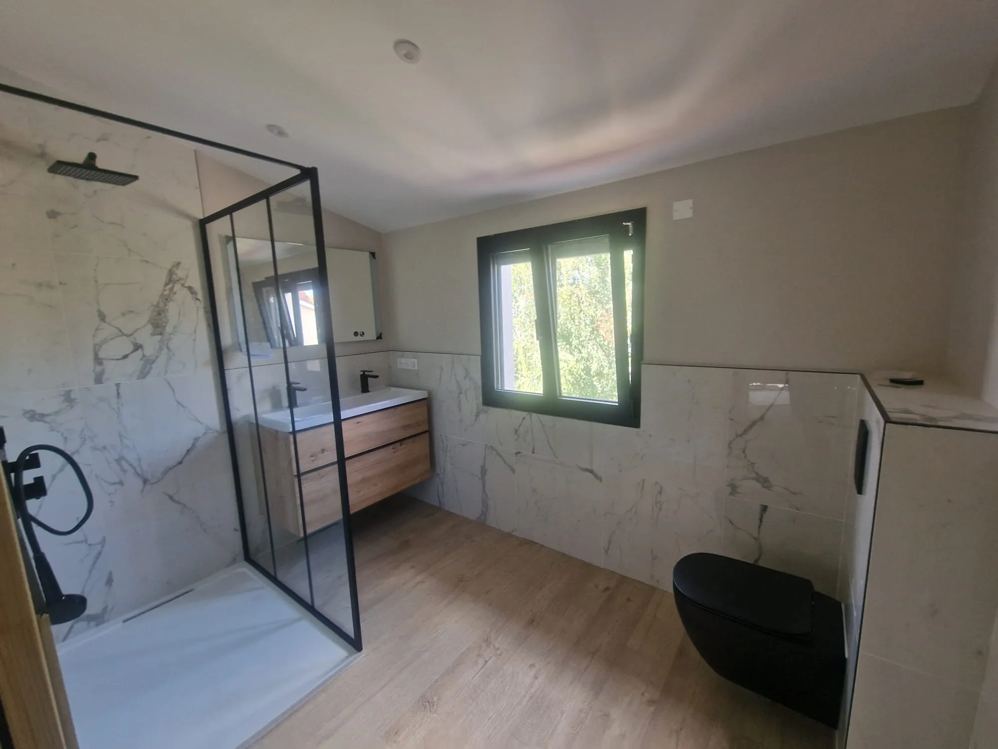 Salle de bain en marbre avec douche à l'italienne réalisée par LDM PLOMBERIE