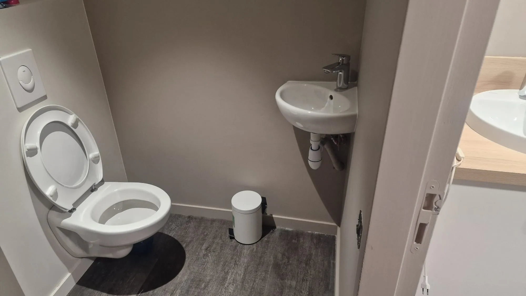 WC suspendu avec lave-mains d’angle optimisant un petit espace